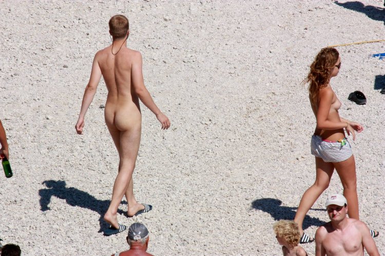 Naked man dressed woman on the beach