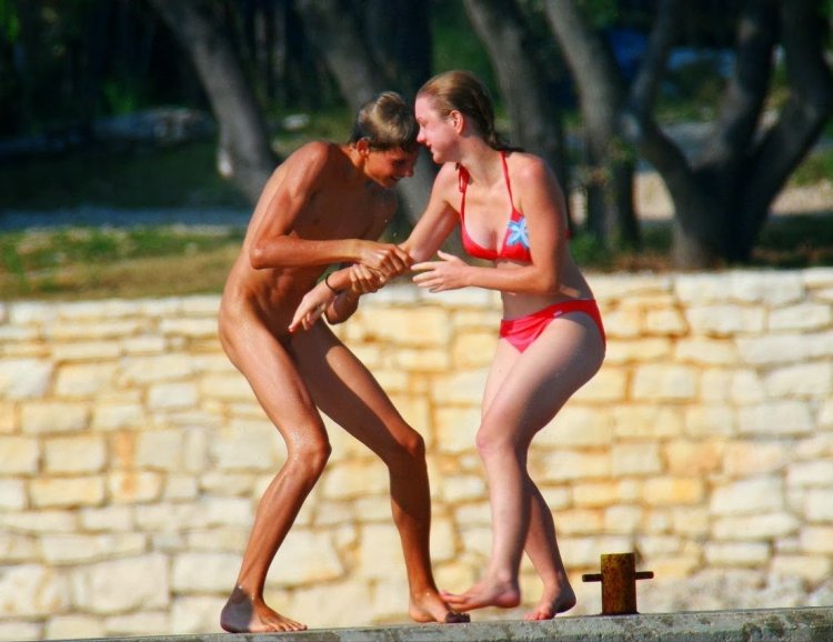 Naked man on the beach with his daughter
