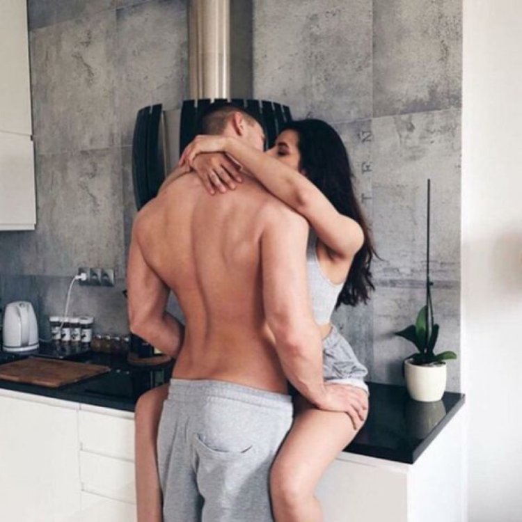 The couple hugs in the kitchen