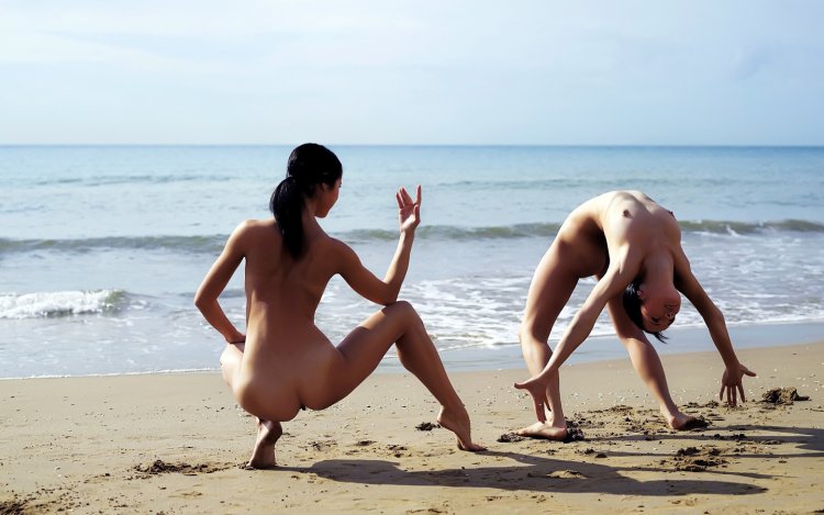 Naked women run along the beach