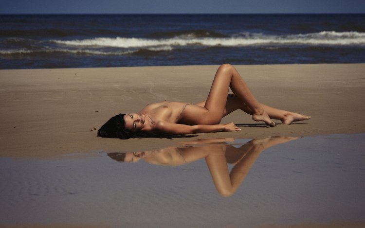 Dog and nude woman on the beach