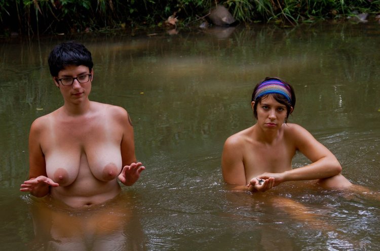 Bare women bathe in the river