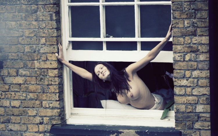 Girl undresses in the window