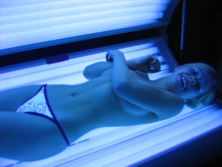 Naked women sunbathe in a solarium