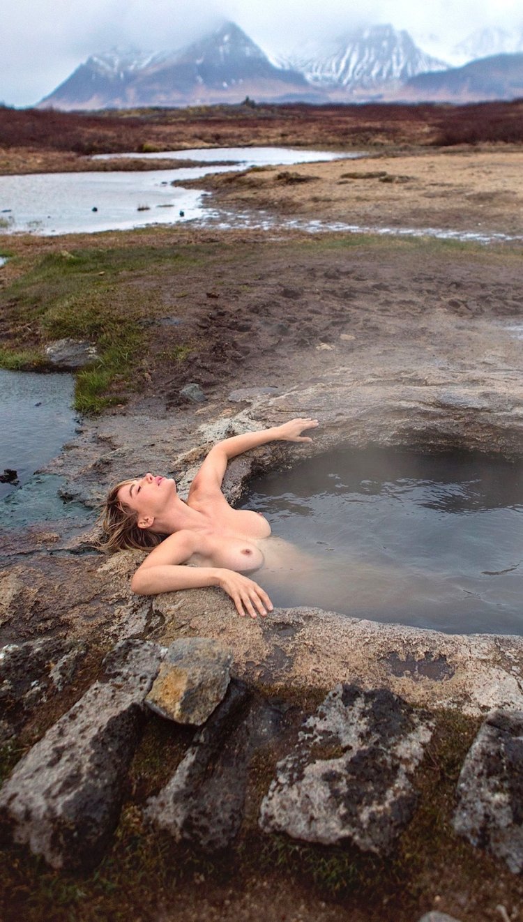 Naked blondes by water on stone