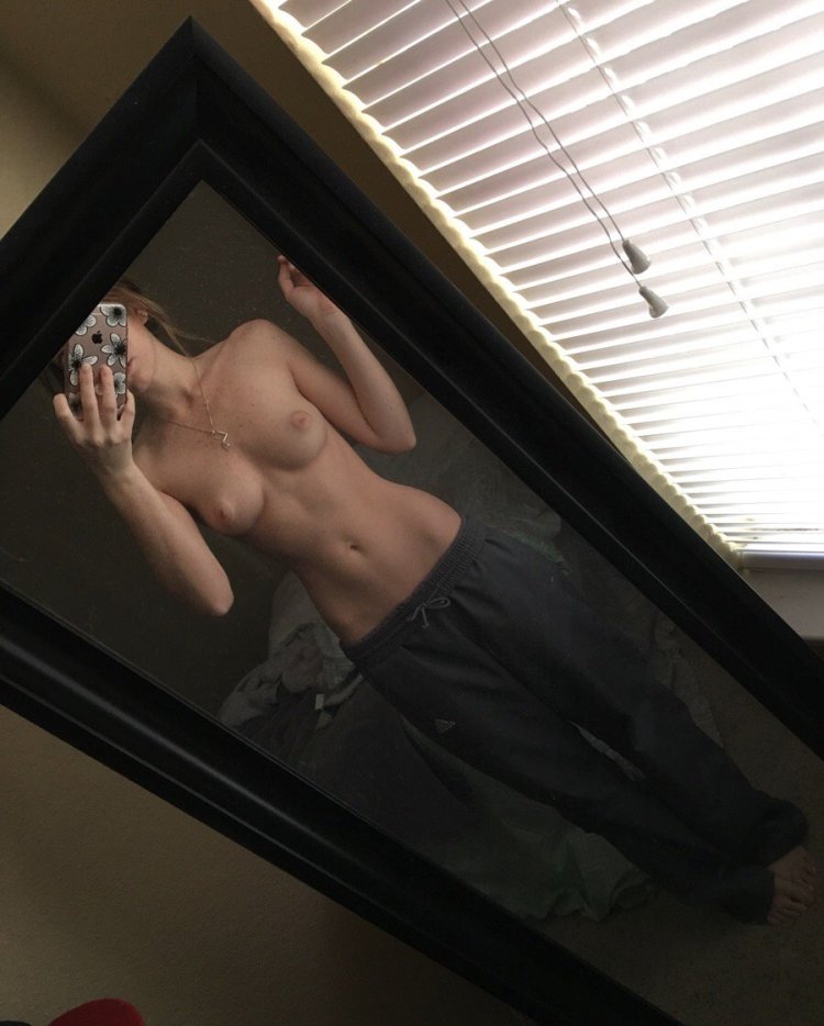 Topless girl in front of the mirror