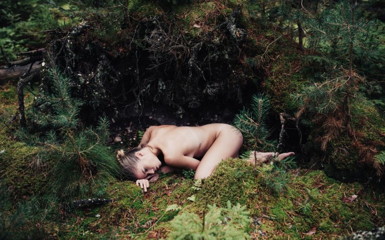 The girl undresses in the forest