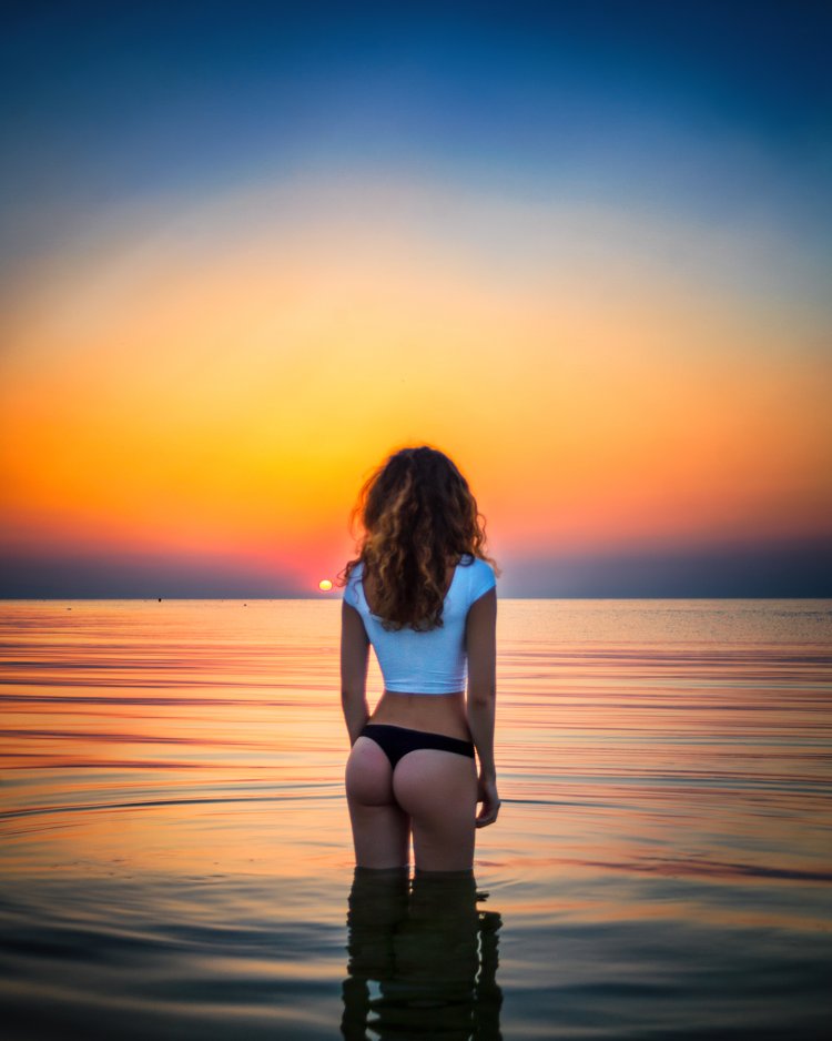 Curly girl at sea sunset