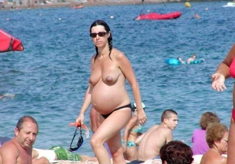 Pregnant topless on the shore