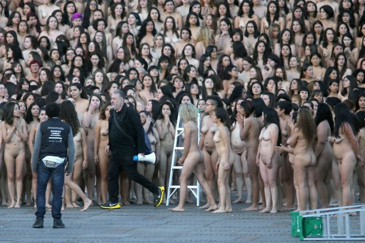 A woman undresses in a crowd of people