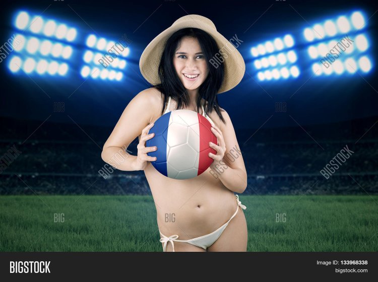 Girl in a bikini holds a football